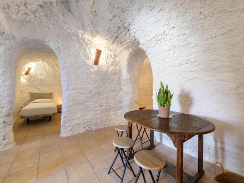a room with a table and chairs and a bed at Holiday Home Casa Cueva Maria Zambrano by Interhome in Terque