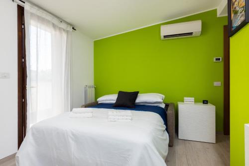 a bedroom with a green wall and a bed at Tram Sotto Casa - In DUOMO in un attimo in Milan