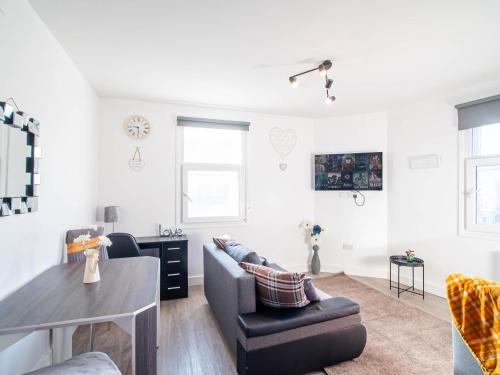 a living room with a couch and a table at The heart of Huddersfield hideaway in Huddersfield