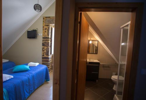 uma casa de banho com uma cama e um lavatrio num quarto em Casas do Terreiro em Seia
