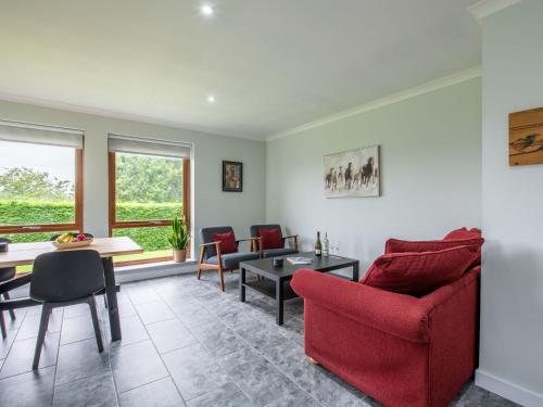 a living room with red chairs and a table at Holiday Home Springbank Lodge by Interhome in Drumnadrochit