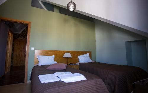um quarto com duas camas com toalhas em Casas do Terreiro em Seia