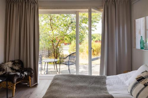 a bedroom with a bed and a sliding glass door at Siggesta Gård in Värmdö