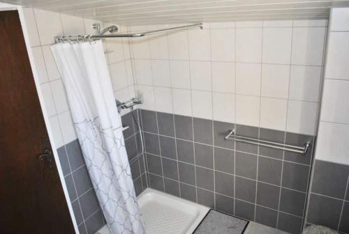 La salle de bains est pourvue d'une douche avec un rideau de douche blanc. dans l'établissement T2 vue sur le château Gréoux, à Gréoux-les-Bains