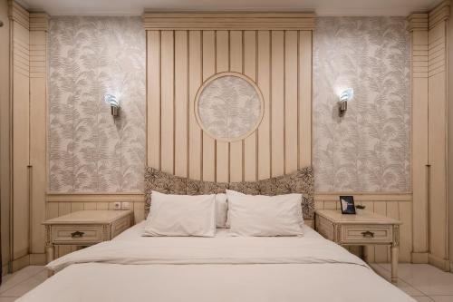 バンドンにあるCove Ottenville Boutique Hotelの大きなベッドと2つのナイトスタンドを備えた寝室