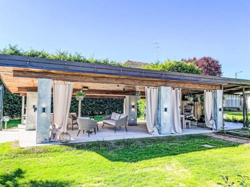a backyard wedding with a pergola with white curtains at Apartment Tenuta Beatrice by Interhome in CastellʼAlfero