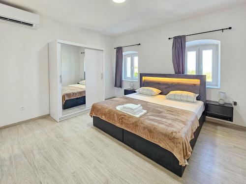 a bedroom with a large bed and two mirrors at Holiday Home Sunrise by Interhome in Janjina