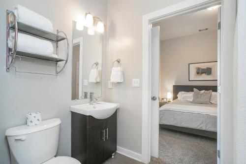 a bathroom with a sink and a toilet and a bed at Music Row w Free Parking in Nashville