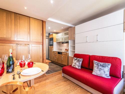 un salon avec un canapé rouge et une table dans l'établissement Studio Le Pramecou - Val Claret-16 by Interhome, à Tignes