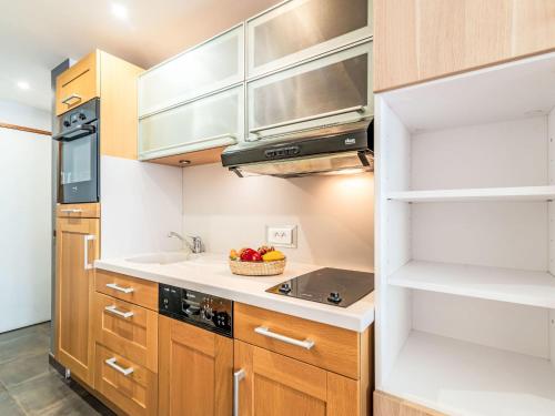une cuisine avec des armoires en bois et un évier dans l'établissement Studio Le Pramecou - Val Claret-16 by Interhome, à Tignes
