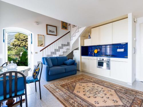 a living room with a blue couch and a staircase at Apartment Loggia sul mare by Interhome in Latte