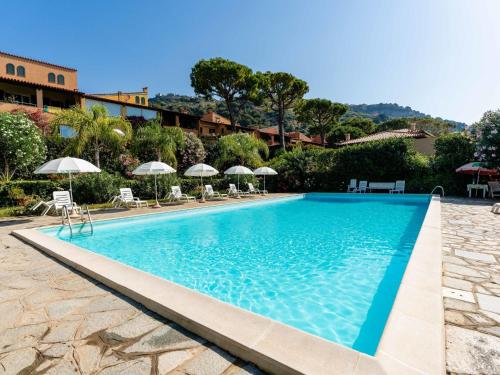a large swimming pool with umbrellas and chairs at Apartment Loggia sul mare by Interhome in Latte
