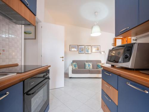 a kitchen with a microwave and a living room at Apartment Vanda by Interhome in Villasimius
