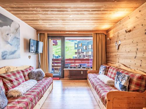 un salon avec un canapé et une grande fenêtre dans l'établissement Apartment Les Hauts du Val Claret - Val Claret-26 by Interhome, à Tignes