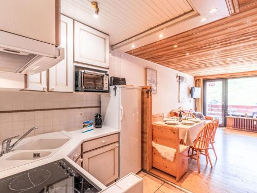 Il comprend une cuisine équipée d'un réfrigérateur et d'une table avec des chaises. dans l'établissement Apartment Les Hauts du Val Claret - Val Claret-26 by Interhome, à Tignes