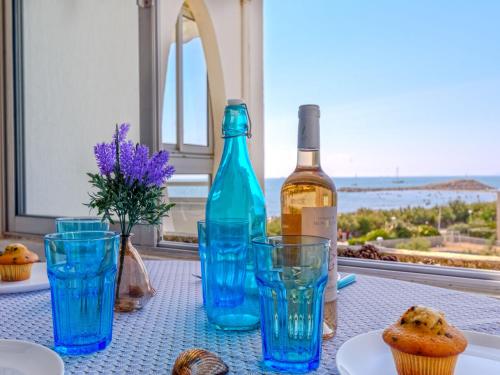 une table avec une bouteille de vin et des cupcakes dans l'établissement Studio Les Terrasses de la Mer-19 by Interhome, à La Grande Motte
