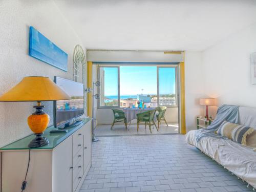 - un salon avec un lit et une table avec des chaises dans l'établissement Studio Les Terrasses de la Mer-19 by Interhome, à La Grande Motte