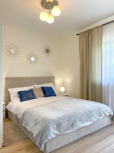 a bedroom with a large white bed with blue pillows at Apartamenty Olszynka in Górki Wielkie
