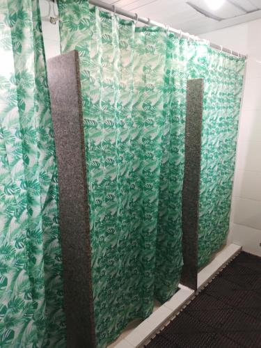 a row of green curtains in a room at Lapa Casa Hostel in Rio de Janeiro