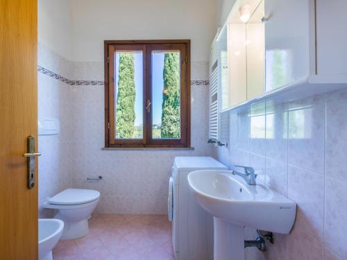a bathroom with a sink and a toilet and a window at Holiday Home Oliveta 2 by Interhome in Fiorino