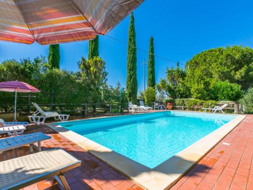 a swimming pool with chairs and an umbrella at Holiday Home Oliveta 2 by Interhome in Fiorino
