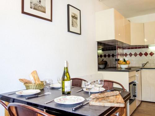 a dining room table with a bottle of wine and bread at Apartment Vanoise-24 by Interhome in Val Thorens