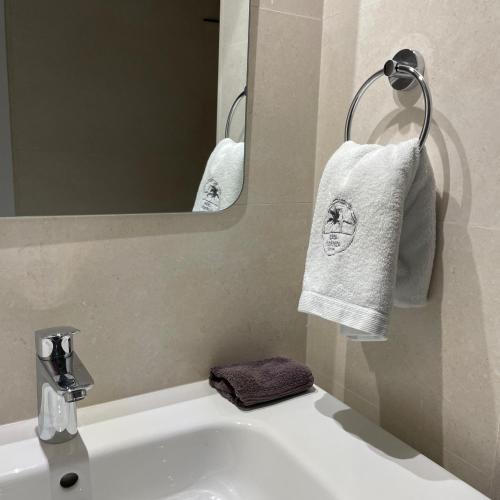 a bathroom with a sink and a mirror and towels at Casa Florinda Tarifa in Tarifa