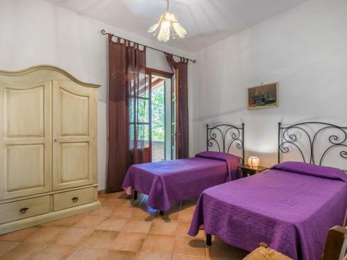 a bedroom with two beds with purple sheets at Holiday Home Oliveta 1 by Interhome in Fiorino
