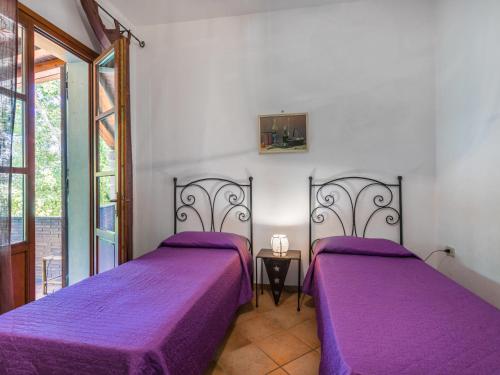 two beds in a room with purple sheets at Holiday Home Oliveta 1 by Interhome in Fiorino