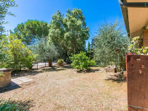 an empty yard with trees and bushes in front of a house at Holiday Home Oliveta 1 by Interhome in Fiorino