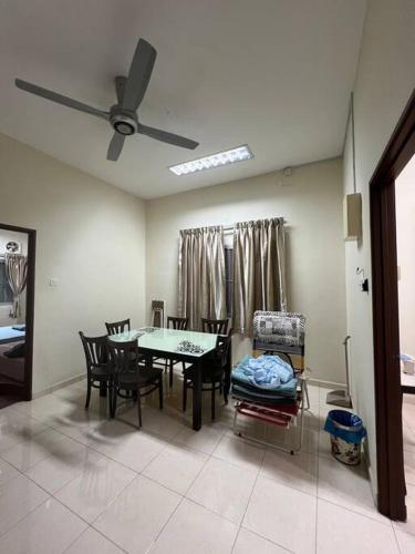 a dining room with a table and chairs and a ceiling fan at Family choice Ling53 in Sitiawan