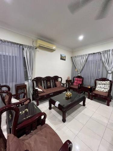 a living room with couches and chairs and a table at Family choice Ling53 in Sitiawan
