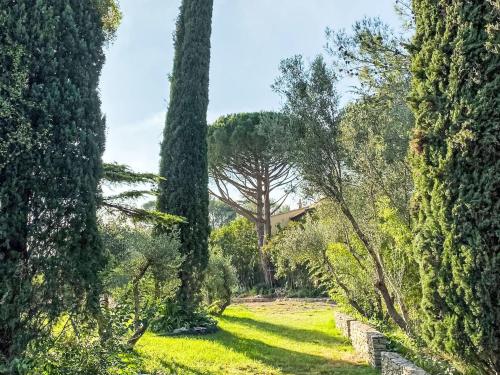 un jardin avec des arbres et une maison au loin dans l'établissement Holiday Home La Bastide de la Cigale by Interhome, à Nîmes