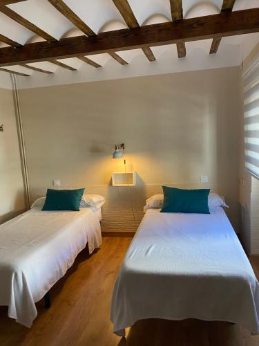 two beds sitting in a room with at Habitacion tienda de felipe EL DESPACHO in Pontones