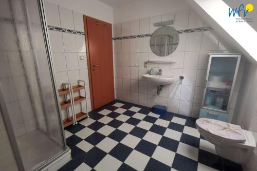 a bathroom with a shower and a toilet and a sink at Huus 24 in Borkum