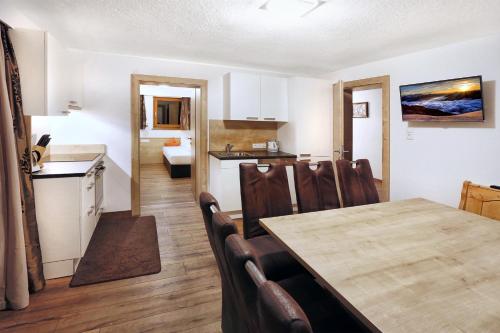 a kitchen and dining room with a table and chairs at A CASA Rubin Chalet & Studio Resort in Sölden