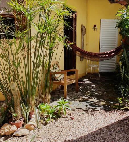 a porch with a bench and a chair next to a building at Casa Solar in Alto Paraíso de Goiás