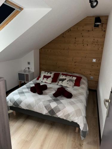 a bedroom with a bed with red pillows on it at Au p’tit nid douillet de Léa in Muhlbach-sur-Munster