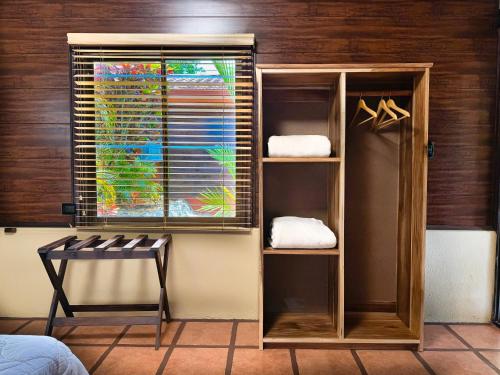 a room with a window and a shelf with towels at Hotel Heliconias Nature Inn & Hot Springs in Fortuna