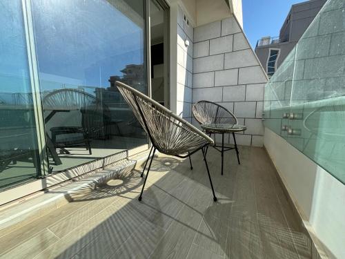 a patio with two chairs and a table on a balcony at Beach Front affordable vacanc in Eilat