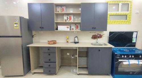 Una cocina con encimera con fregadero y frigorífico. en فيلا نون, en El Cairo