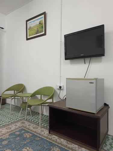 Kampong JelutongにあるOne Mek Roomstayのリビングルーム(テレビ、テーブル、椅子付)