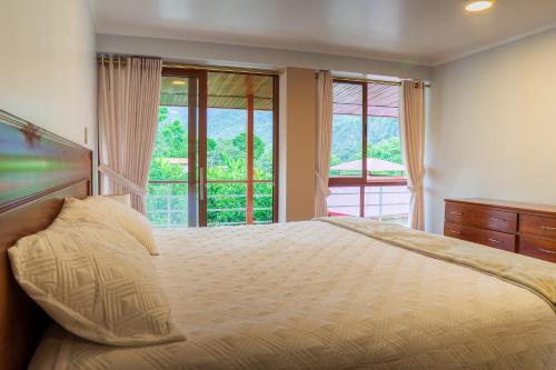 a bedroom with a bed and a large window at Villa San Ramon - BIG HOUSE - Chamchamayo in San Ramón