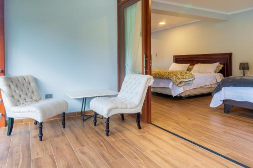 a bedroom with two beds and a table and two chairs at Villa San Ramon - BIG HOUSE - Chamchamayo in San Ramón