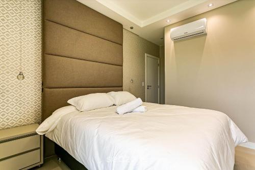 a bedroom with a large bed with white sheets at Sophisticated fit with 3 suites Jurere LES403 in Florianópolis