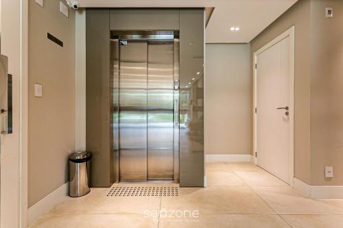 a hallway with a glass elevator in a house at Sophisticated fit with 3 suites Jurere LES403 in Florianópolis