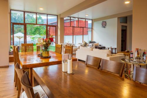 a dining room and living room with a table and chairs at Villa San Ramon - BIG HOUSE - Chamchamayo in San Ramón