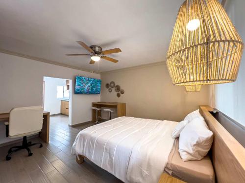 a bedroom with a bed with a ceiling fan and a desk at Modern Apartment with Home Office in Prime Location in Querétaro