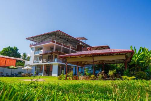 a large building with a grass field in front of it at Villa San Ramon - BIG HOUSE - Chamchamayo in San Ramón
