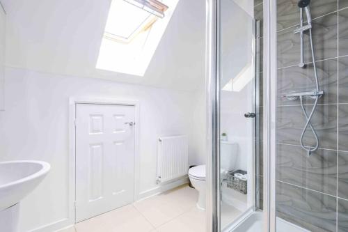 un bagno con doccia, WC e lavandino di Spacious 4-Bed Manchester Home a Manchester